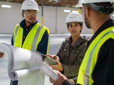 Three people working in a warehouse