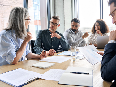 Personnes assises autour d'une grande table dans un bureau